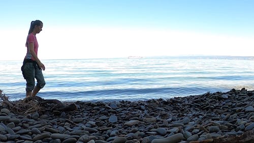 Woman Walking on a Rocky Shore