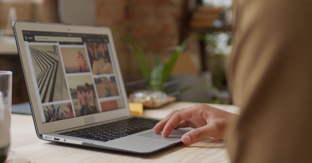 Una Persona Mirando Fotos En Su Computadora Portátil · Vídeo de stock gratuito