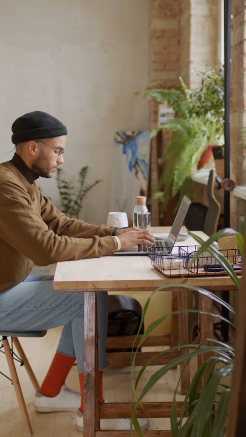 A Young Man Busy Typing On His Laptop