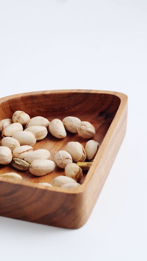 Falling Pistachios on Wooden Plate