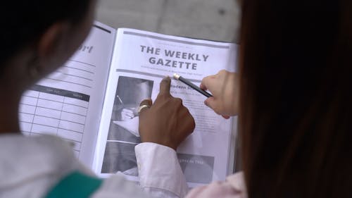 Женщины, читающие еженедельник