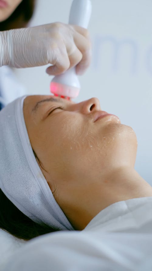 A Specialist Doing Ultrasonic Facial to a Woman