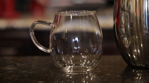 Person Pouring Coffee in a Mug