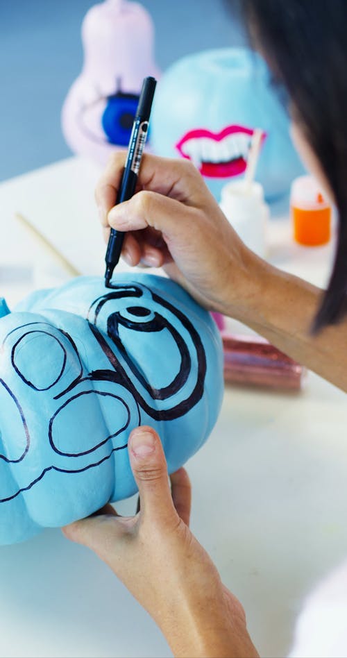 Person Decorating the Pumpkin