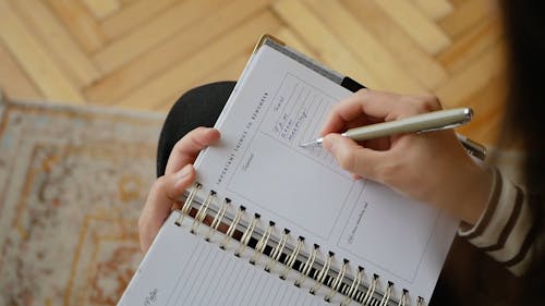 Woman Writing her Schedule in a Planner
