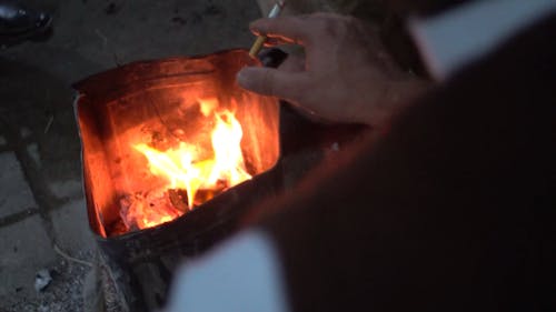 Close-Up View of a Person Smoking by the Fire Pit
