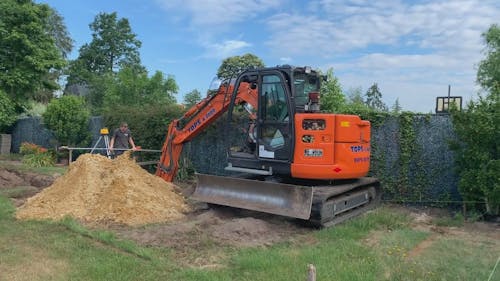 People Digging Soil Using a Mini Excavator