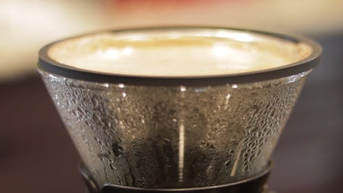 A Person Pouring Hot Water on a Coffee Brewer