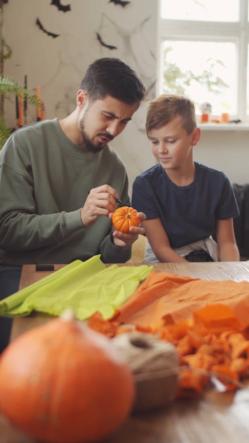 A Father Showing His Son How To Make Halloween Decors