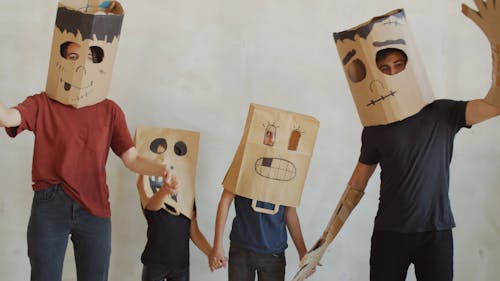 A Family Wearing Paper Bag Masks For Halloween