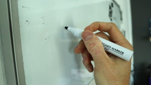 A Person Writing on a Whiteboard