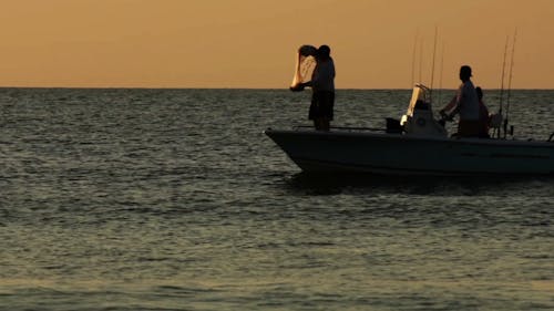 Man on Boat Throwing Fishing Net