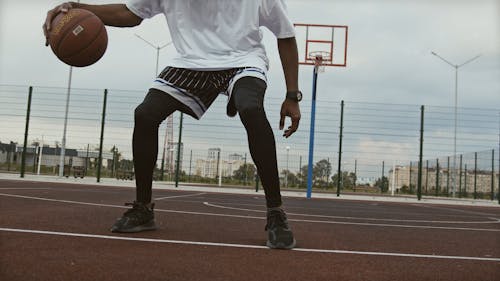 Man Dribbling a Ball on Basketball Court