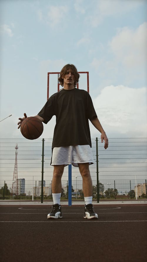 Man Dribbling a Ball on Basketball Court