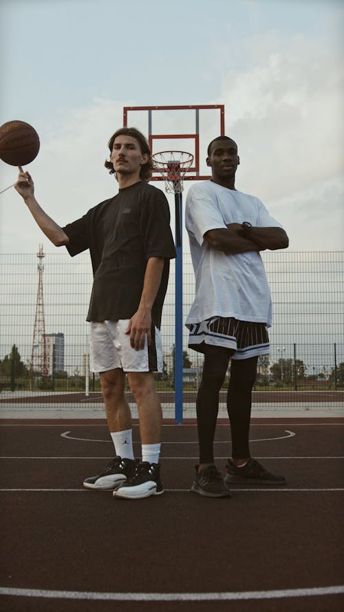 Two Young Men Standing at a Basketball Court