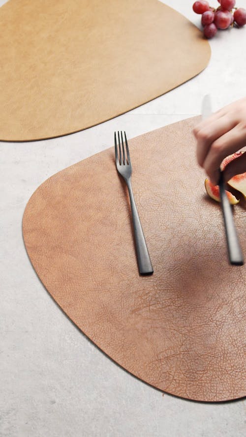 A Person Putting Silverware on a Placemat
