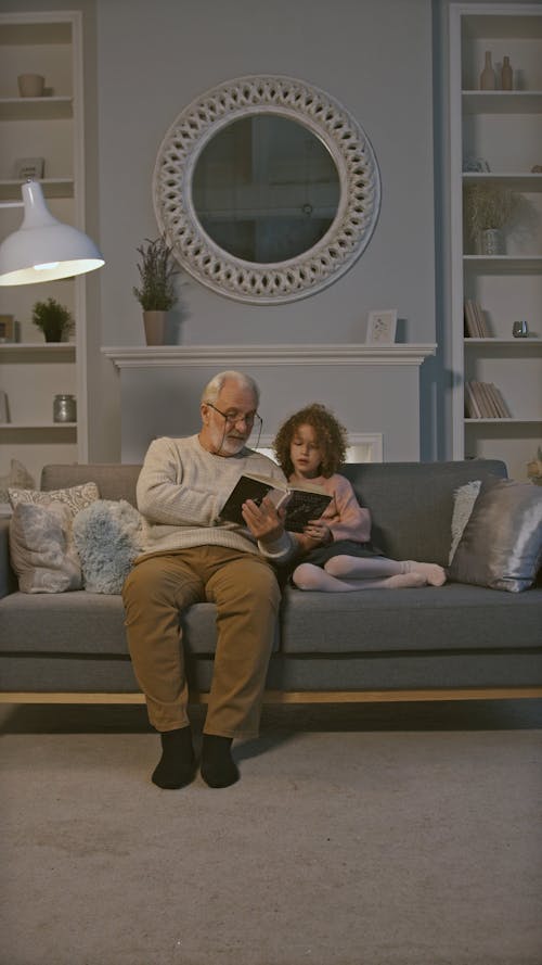 Grandfather Reading a Book to his Granddaughter