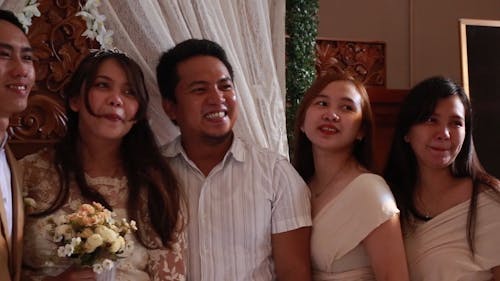 Groom and Bride with Their Guests Standing while Smiling