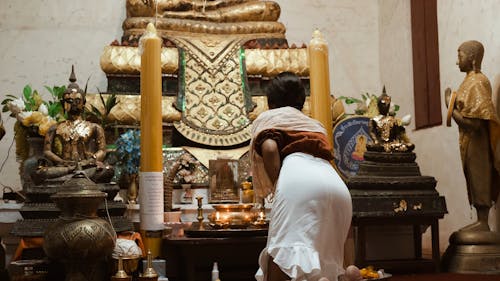 A Buddhist Person Praying In Front of the Altar