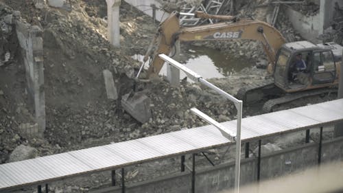 A Person Operating a Backhoe for Excavation