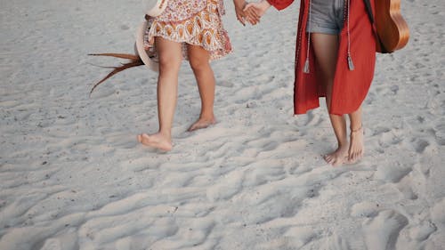 People Walking on the Beach While Holding Hands