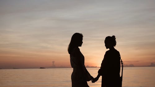 People Standing at the Beach on a Sunset