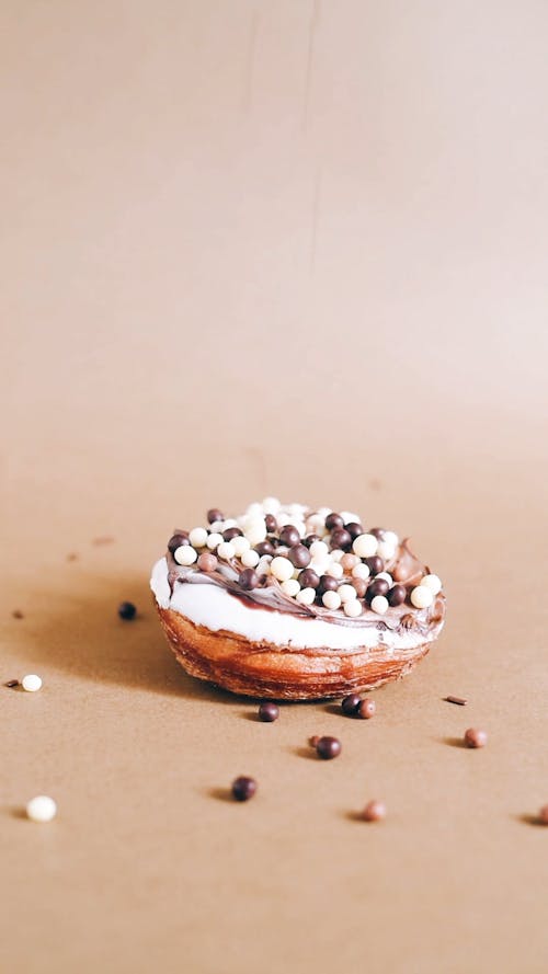Sprinkling Toppings Over a Donut