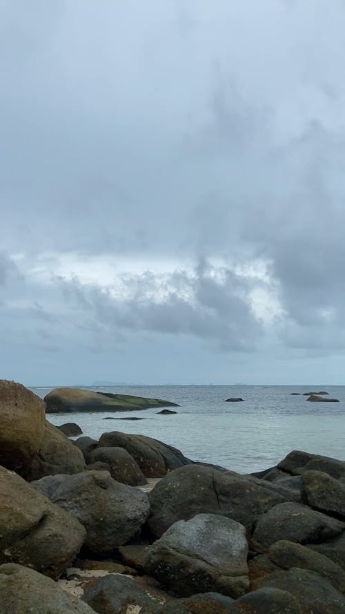 Natural Rock Formations on Beach Under Cloudy Sky