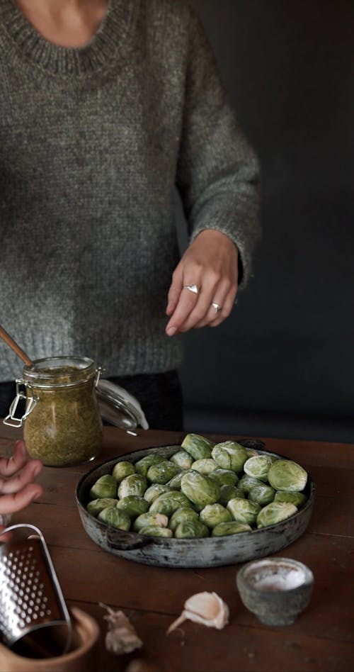 Person Grating Garlic over Brussels Sprouts