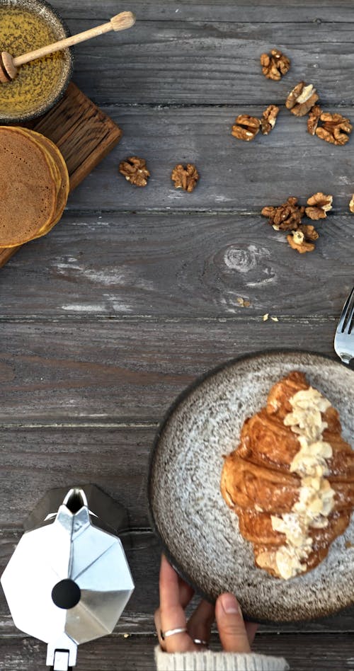 A Person Serving Croissant on a Plate