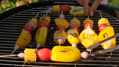 Person Cooking Vegetables on a Grill