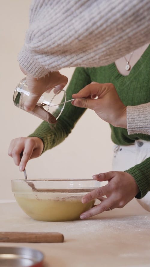 Girl Adding Chocolate Powder On A Batter