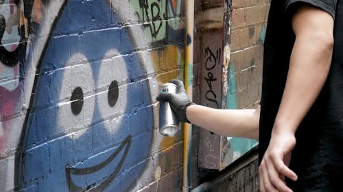 A Person Doing Graffiti Art by Using a Spray Paint