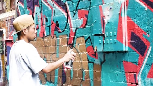 A Man Doing Graffiti Art by Using a Spray Paint