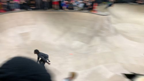 Group of People Watching a Man Roller Skating in a Skatepark