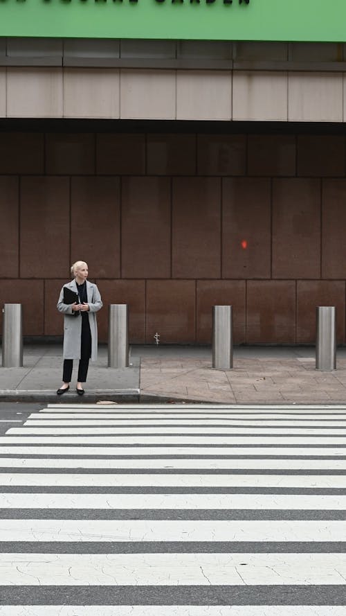 Woman Standing on a Pedestrian Lane