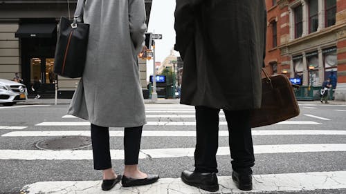 A Man and Woman in Business Attire Standing at Pedestrian Crossing