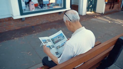 Back View of an Elderly Man Reading a Magazine