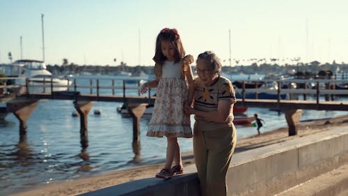防波堤の上を歩いて子供を抱いている祖母