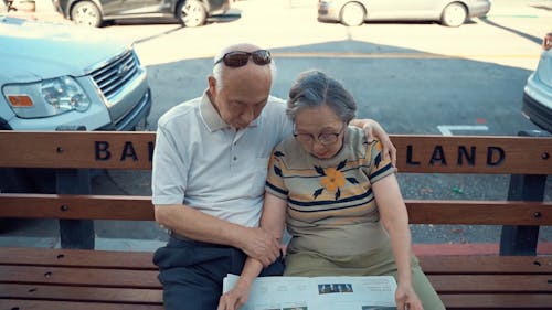 An Elderly Couple Reading The Newspaper