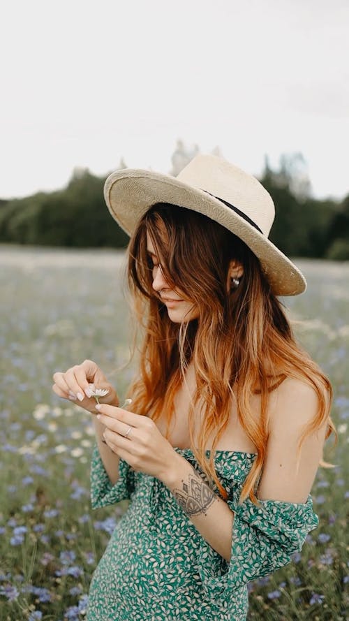 A Woman In The Middle Of The Grass Flower Field