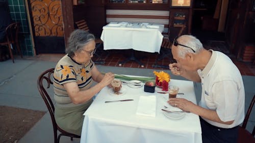 An Elderly Couple Eating In An Outdoor Restaurant 