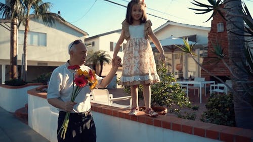 Elderly Man Holding Girl's Hand while Walking
