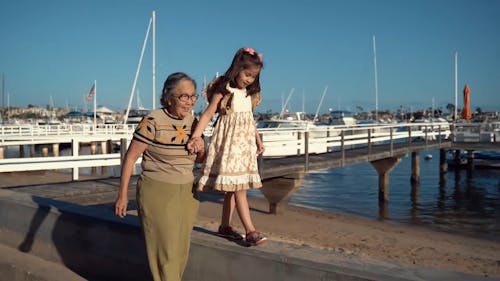 Grandma Holding Granddaughter's Hand while Walking