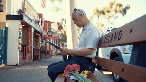 An Elderly Man Reading The Newspaper