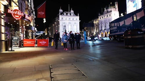 People Walking on Sidewalk During Nighttime