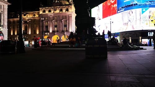 People Walking on a Sidewalk During Nighttime