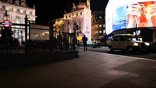 People Walking on Sidewalk During Nighttime