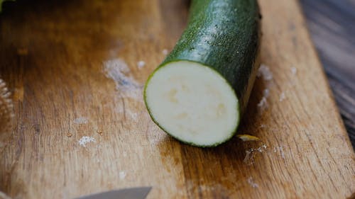 Vista En Primer Plano De Una Persona Cortando Calabacín Con Un Cuchillo