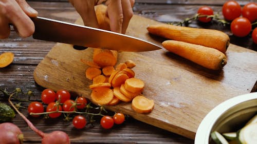 A Person Slicing Up the Carrots by Using a Knife